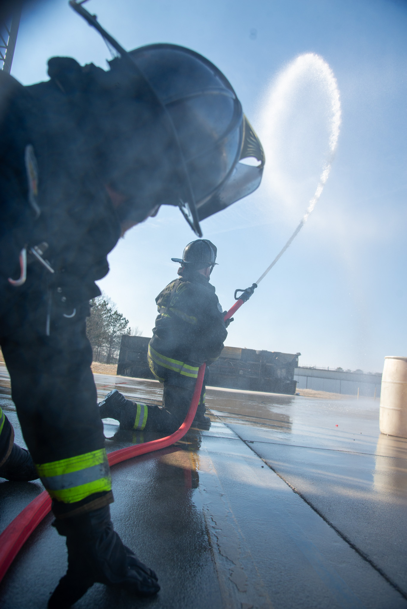 two firefighters flowing water into the air outside