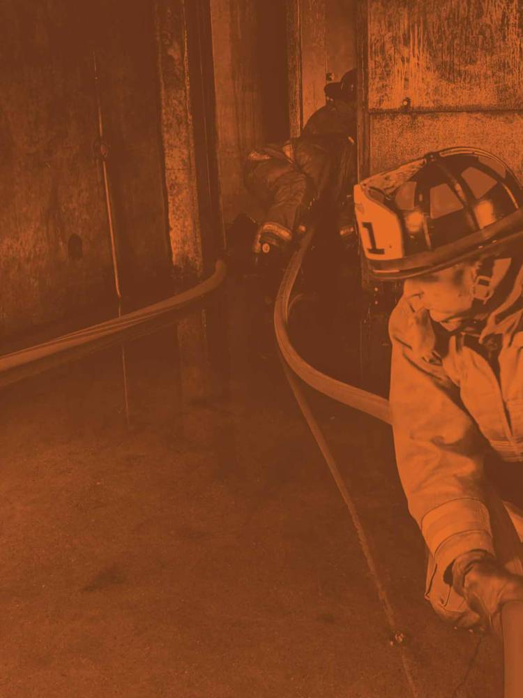 Two fireman with hose orange tint