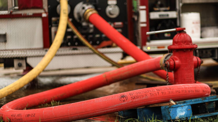 A bright red hose attached to a red fire hydrant—Mercedes Textiles Know Your Hose Resource
